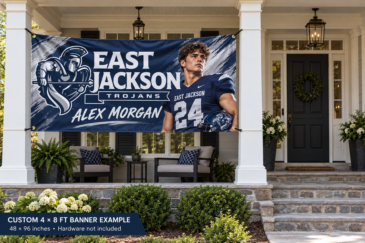East Jackson Trojans custom 4 by 8 foot banner example with photo, name and jersey number; four corner grommets secured between porch pillars beside an unobstructed entrance.