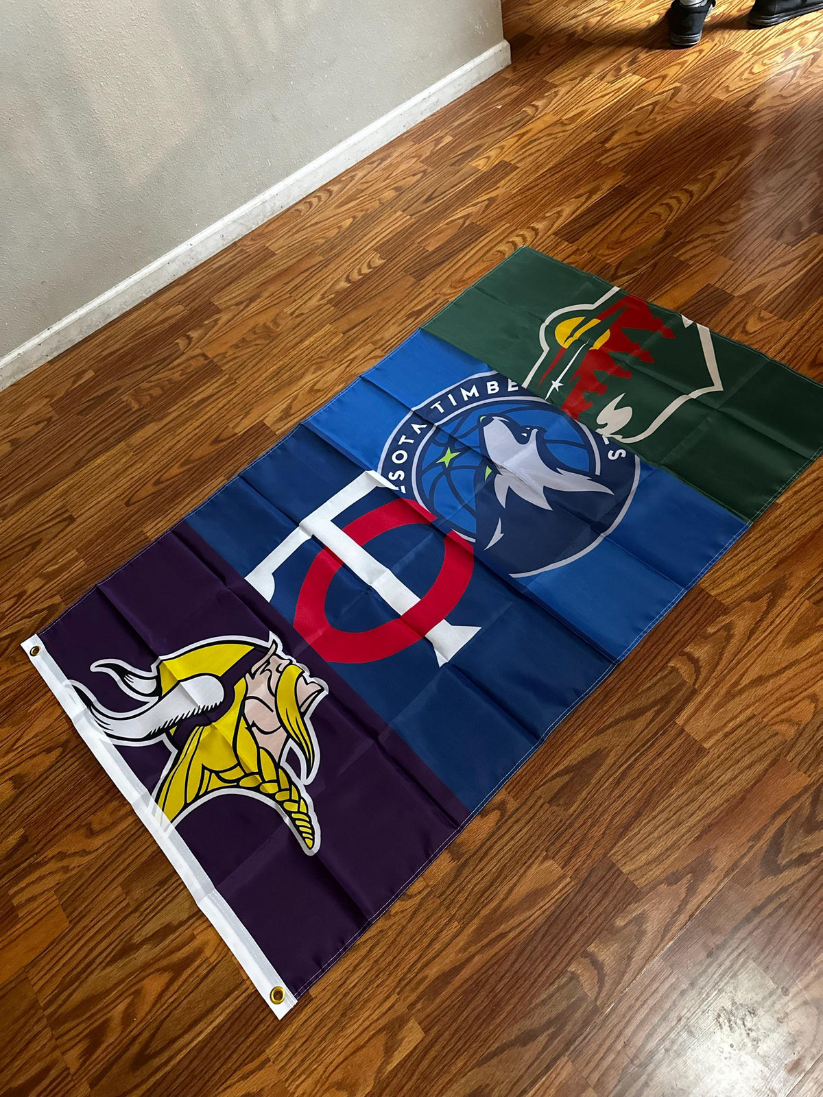 Customer photo of a custom Minnesota four-team flag with a reinforced grommet edge