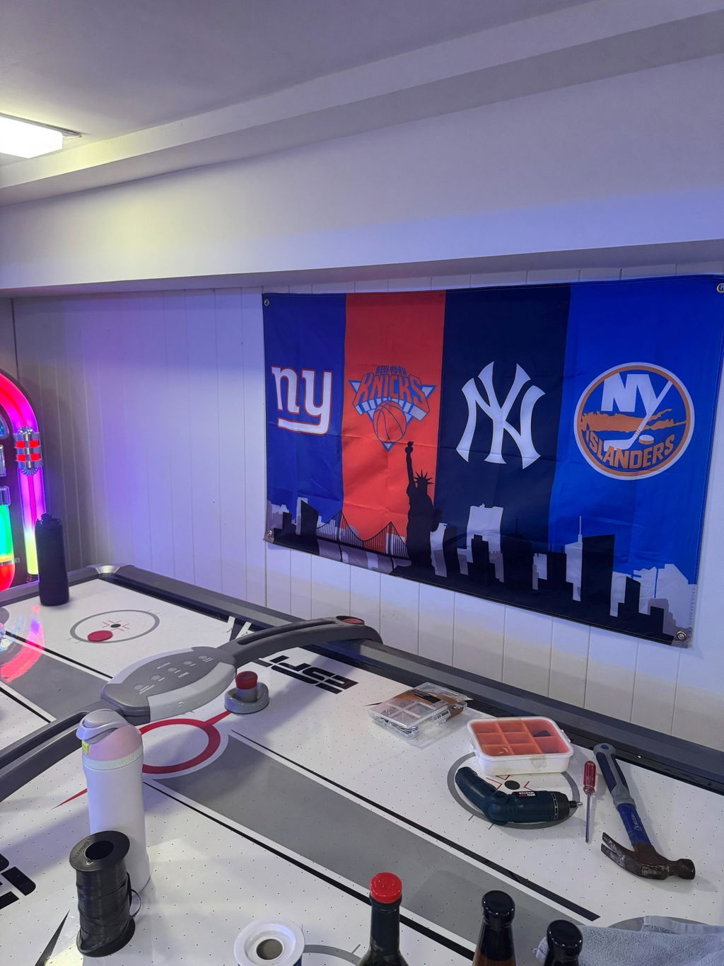 Customer photo of a custom four-team New York skyline flag in a game room