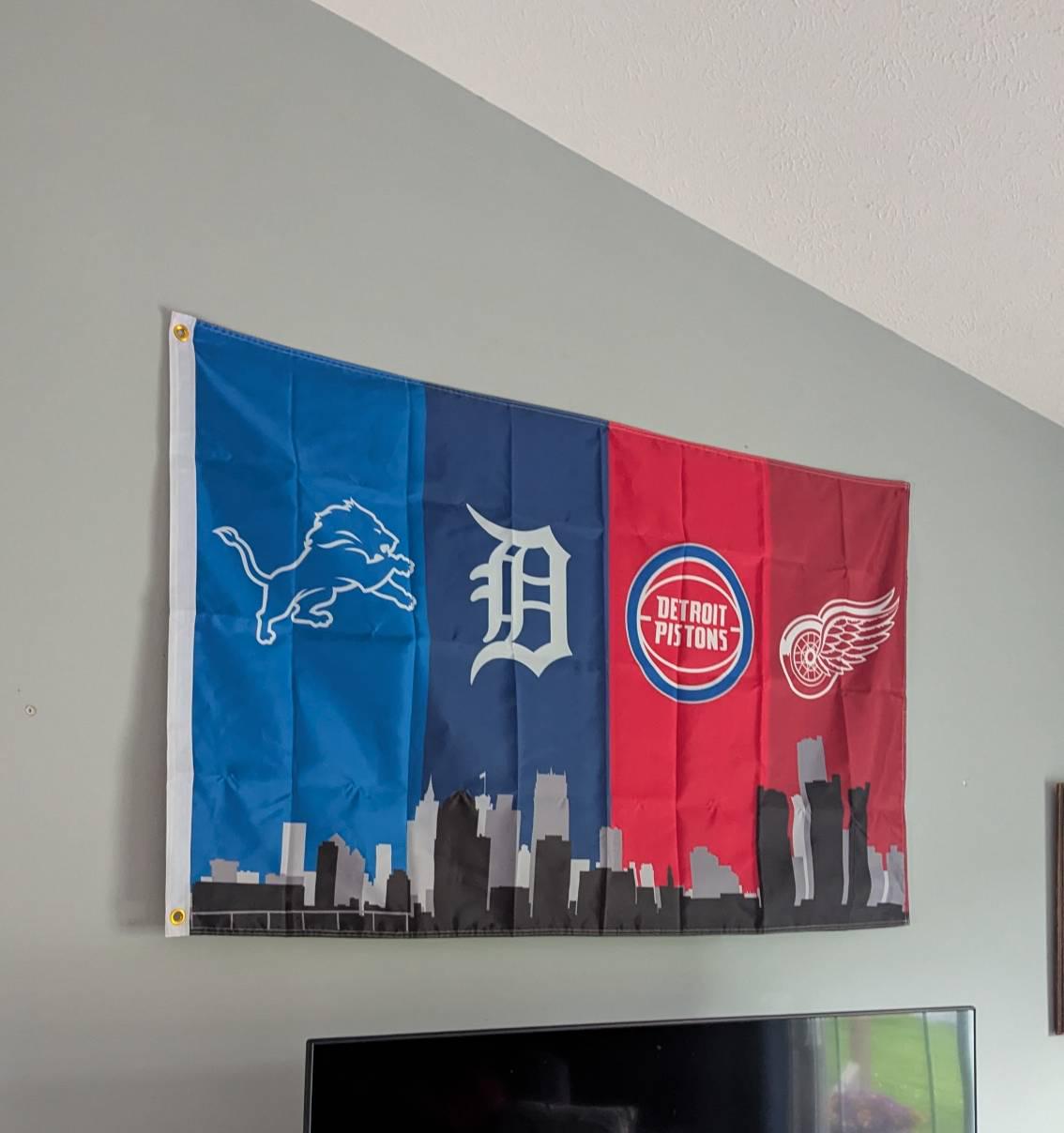 Customer photo of the Detroit four-team skyline flag displayed above a television