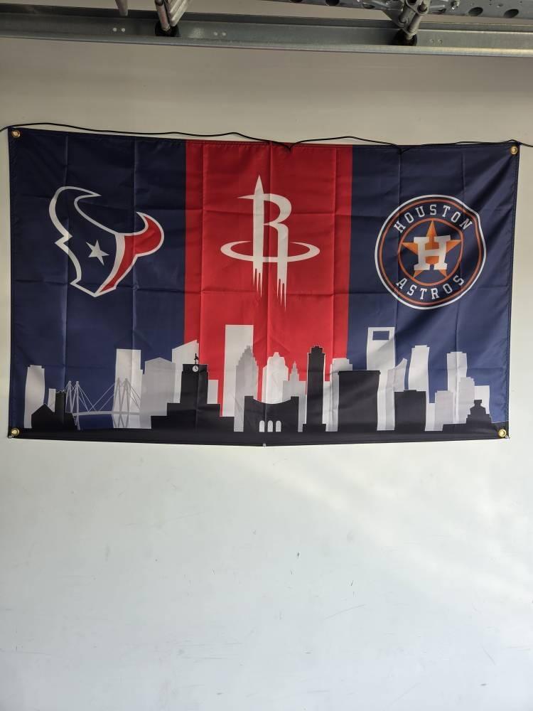 Customer photo of the Texans, Rockets and Astros skyline flag hanging on a wall