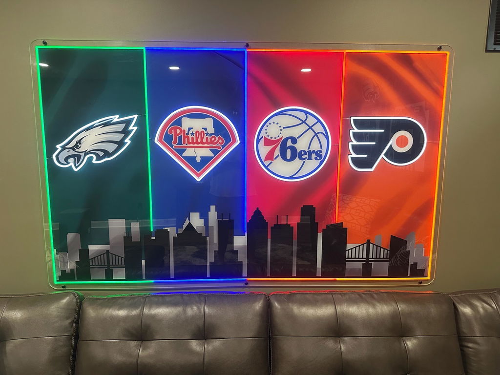 Customer photo of the Philadelphia four-team LED skyline sign installed above a sofa